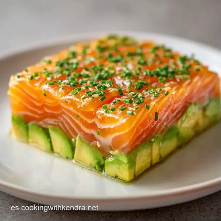 Torre cil&iacute;ndrica de pescado fresco picado, adornada con brotes verdes y gotas de aceite brillante sobre porcelana blanca.